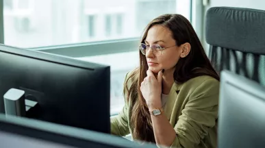 mulher olhando para computador pensativa.