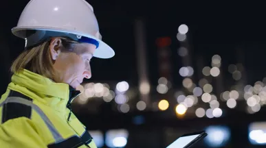 profissional com capacete de proteção trabalhando à noite.