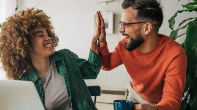 Dois colegas de trabalho comemoram o prêmio recebido pela Pluxee Brasil