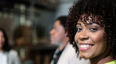 Profissional sorri na fábrica em que trabalha