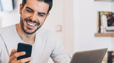 pessoa sorrindo olhando para o celular.