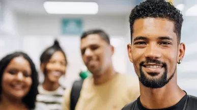 vários jovens sorrindo em ambiente corporativo.