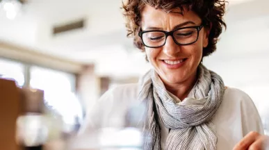 A imagem mostra uma mulher de óculos se alimentando em um restaurante