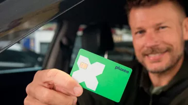 Rodrigo Hilbert dirigindo com o cartão Pluxee na mão