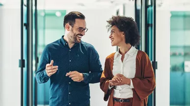 duas pessoas conversando em corredor de escritório.
