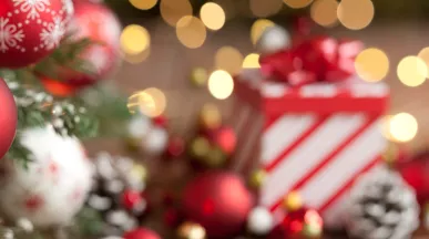 Imagem mostra uma mesa de Natal com um presente ao fundo