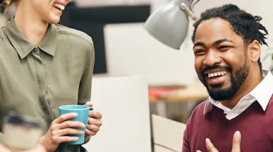 pessoas sorrindo e conversando em ambiente corporativo.