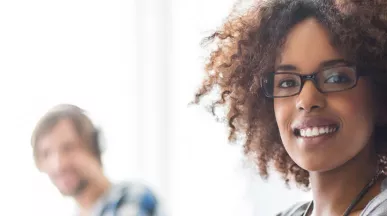 mulher sorrindo para a câmera em ambiente de trabalho.