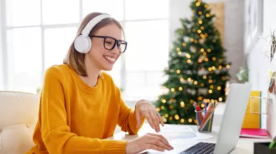 Colaboradora trabalha em home office com árvore de Natal ao fundo
