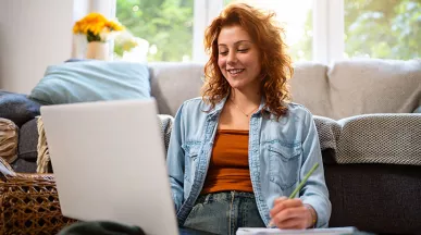 mulher sorrindo em frente ao computador.