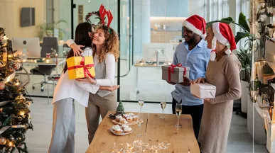 pessoas trocando presentes de natal em escritório.