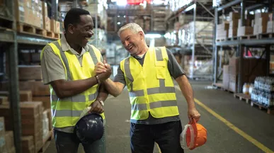 Foto mostra dois funcionários de uma empresa comemorando os resultados do final de ano