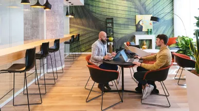 Imagem mostra duas pessoas em reunião no escritório