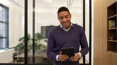 Foto mostra uma pessoa no escritório trabalhando no seu tablet