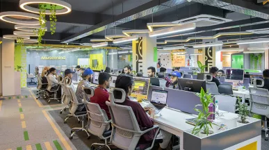 Foto mostra pessoas trabalhando em um escritório amplo