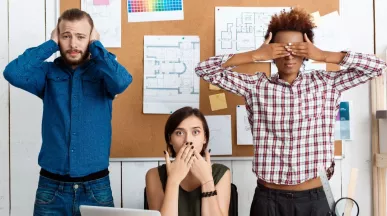 três pessoas imitando os “três macacos sábios”, da cultura japonesa.