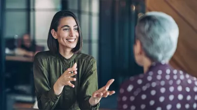 duas mulheres conversando em um ambiente corporativo 