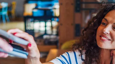 mulher pagando compra com celular.
