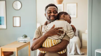 pai segurando o filho no colo.