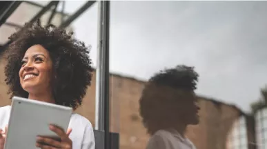 Mulher negra com tablet sorrindo