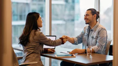 Foto mostra duas pessoas fazendo uma reunião no escritório