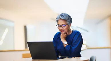 mulher sorrindo para computador.
