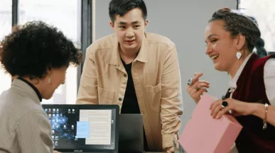 homem e duas mulheres conversando em ambiente de trabalho