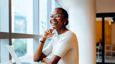 Foto mostra uma mulher animada no seu local de trabalho