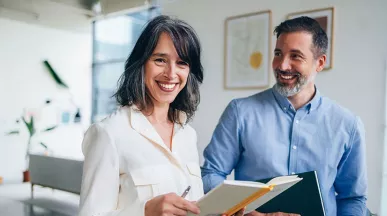 duas pessoas sorrindo no ambiente de trabalho.