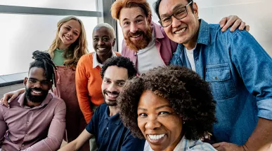 equipe de trabalho diversa sorrindo para selfie.