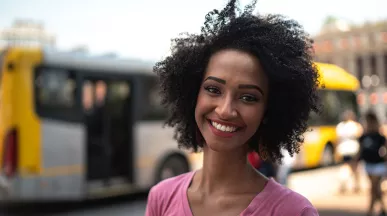 mulher sorrindo em frente a onibus.