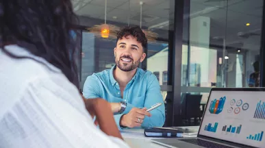 suas pessoas conversando enquanto notebook mostra uma série de gráficos.