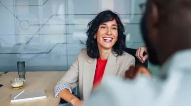 mulher e homem conversando e sorrindo em escritório.