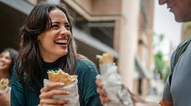 mulher almoçando e sorrindo.