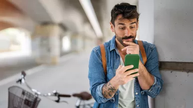 homem olhando o celular depois de andar de bicicleta.