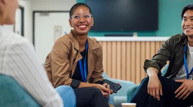 pessoas sorrindo em roda de conversa no trabalho.