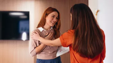 duas mulheres se abraçando no trabalho.