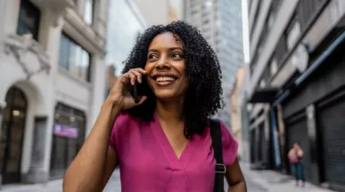 mulher negra, segurando o celular e sorrindo