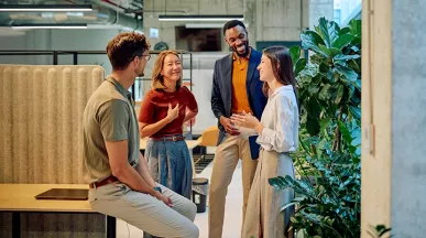 conjunto de pessoas conversando em ambiente corporativo.