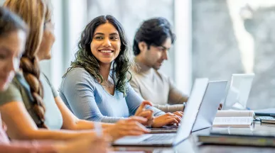 mulher sorrindo para companheiros de estudos.