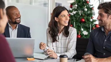 pessoas trabalhando com árvore de natal ao fundo.