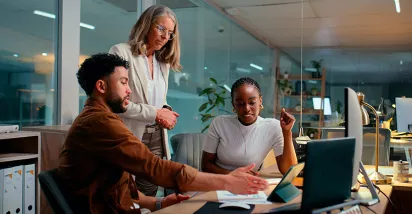 Foto mostra uma equipe fazendo reunião de trabalho numa sala