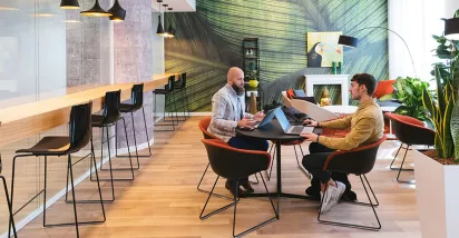 Imagem mostra duas pessoas em reunião no escritório