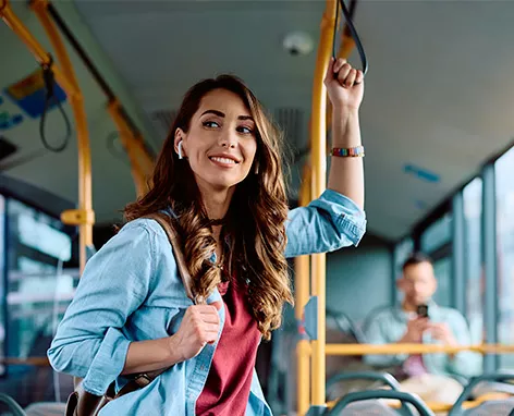 Foto mostra uma mulher indo para o trabalho de ônibus