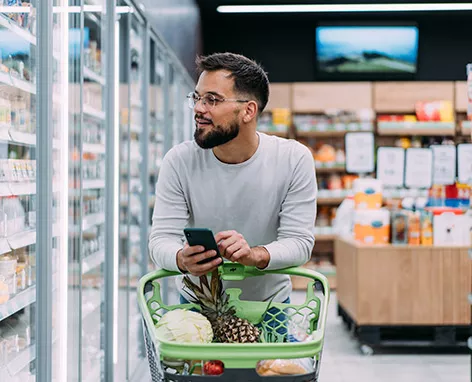 Foto mostra um homem fazendo compras no supermercado