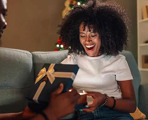 Foto mostra uma mulher ganhando um presente