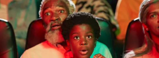 Foto mostra uma família assistindo filmes