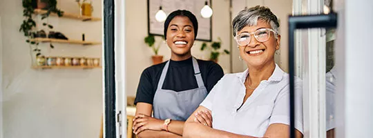 Empreendedora posa com funcionária em seu comércio