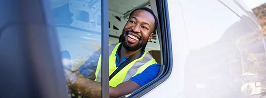Motorista de van sorri durante o trabalho