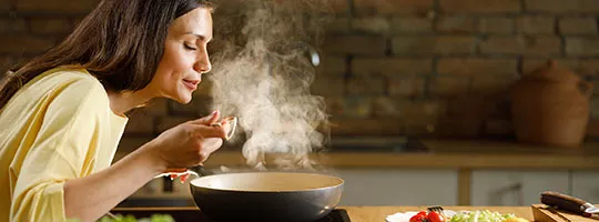 Mulher cozinha economizando no gás de cozinha
